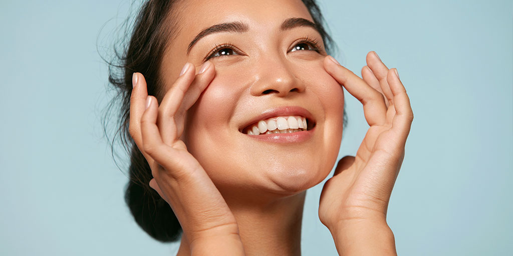 Smiling woman touching her face