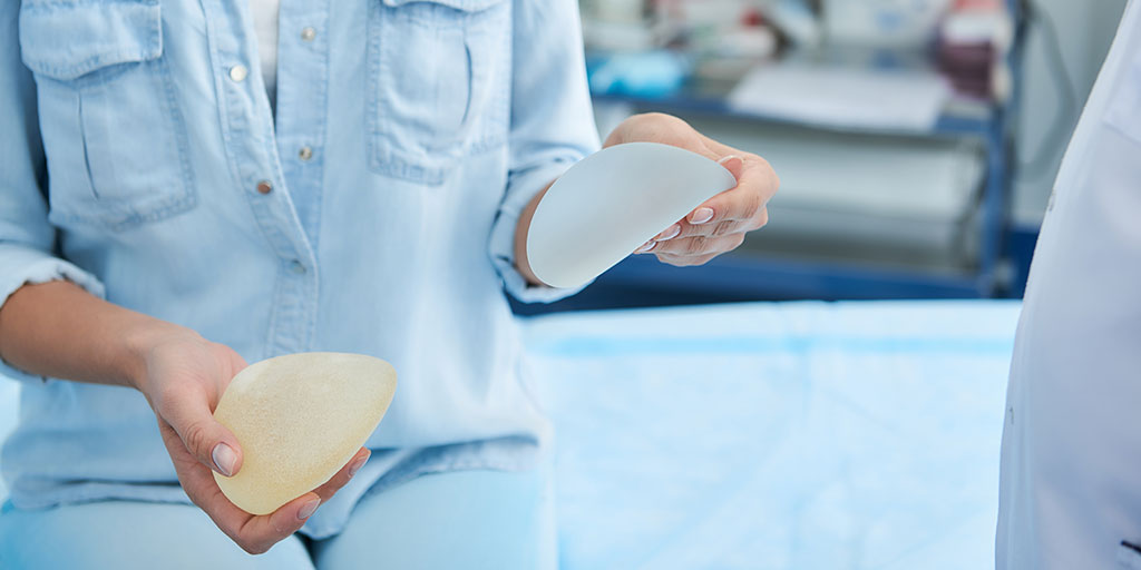 Woman holding breast implants