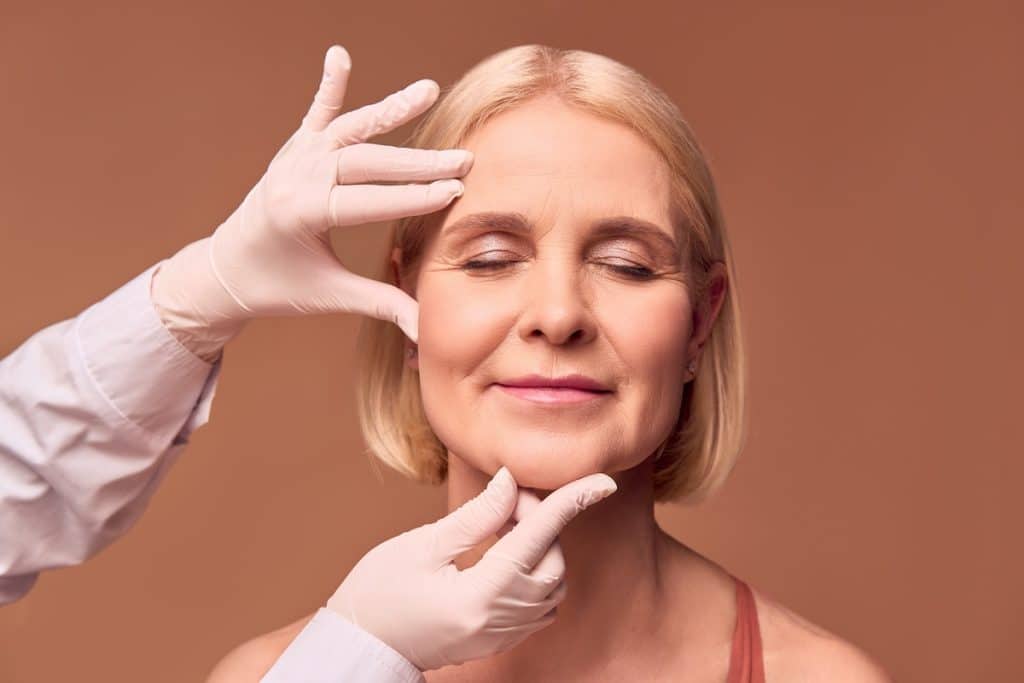 Woman with eyes closed receiving gentle facial exam